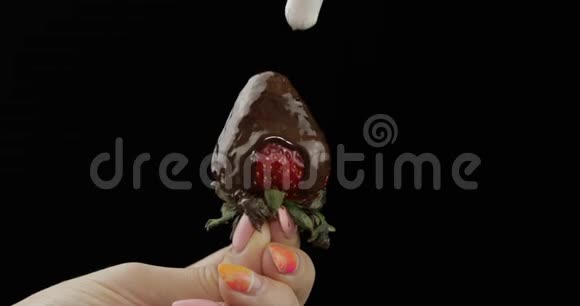 草莓和融化的巧克力把鲜奶油挤在浆果上面视频的预览图