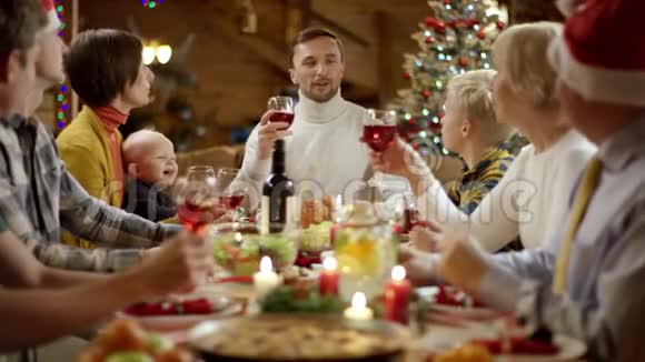 一家之主在圣诞餐桌旁祝酒每个人都在鼓掌视频的预览图