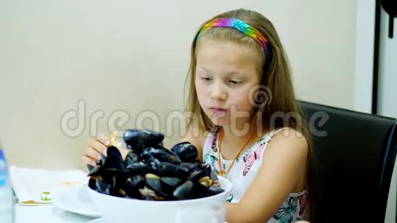 特写在餐厅里小姑娘端上了桌上的一大碗一盘熟透的蓝色贻贝儿童视频的预览图