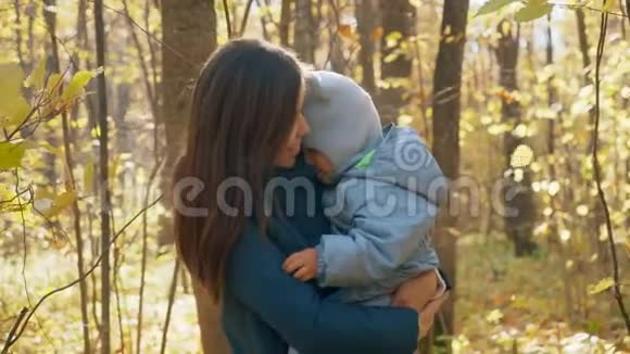 年轻的母亲和她的小儿子在秋天公园妈妈怀里的小男孩4K视频的预览图