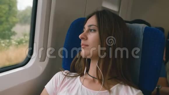 站在火车窗外的一个漂亮的年轻女人旅行运输概念视频的预览图