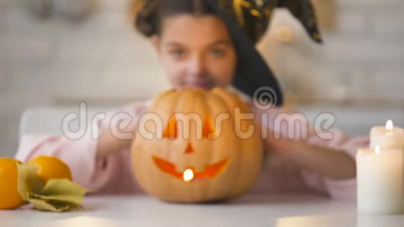 小女巫展示恐怖的南瓜灯准备万圣节派对视频的预览图