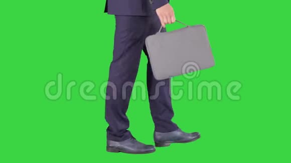 英俊的商人穿着西装带着公文包走在绿色屏幕上ChromaKey视频的预览图