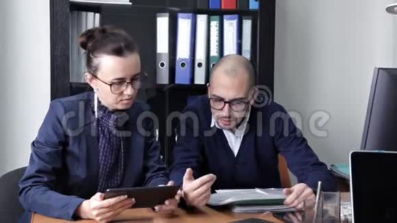 一位年轻的老板和他的助手坐在办公室讨论工作计划视频的预览图