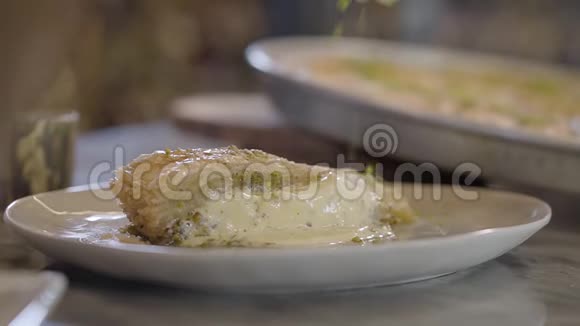 东方甜盘kunafa配芝士洒上开心果就近了餐厅的食物准备视频的预览图