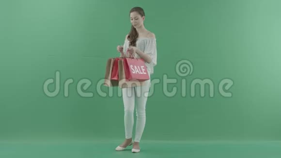 女人从绿色屏幕上的袋子里拿出衣服视频的预览图