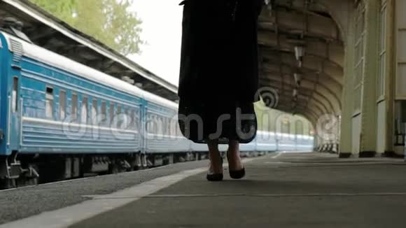 火车站穿着黑色外套的漂亮中年黑发女人穿鞋走路腿的特写视频的预览图