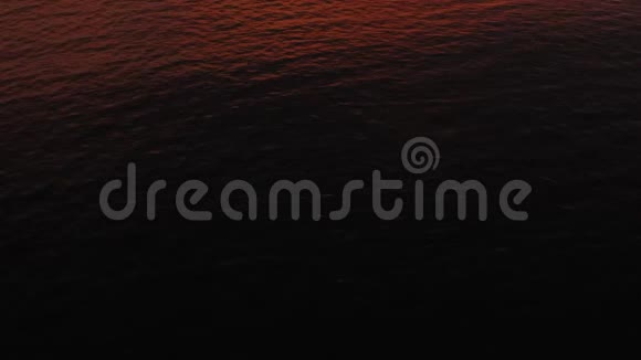 日落于海面鸟瞰日落于海面背景是红色的天空和岛屿在大海上飞翔视频的预览图