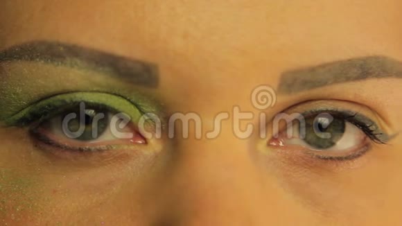 女性的眼睛一只眼睛染上了明亮的绿色阴影视频的预览图