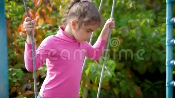 年轻漂亮的女孩在秋千上玩得很开心孩子在秋千上摆动4k60fps慢动作视频的预览图