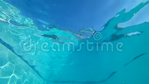 穿着泳装微笑的女性在纯泳池中张开眼睛漂浮在水中视频的预览图