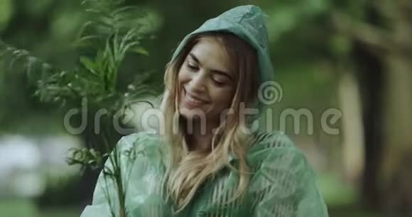 特写微笑的美女穿着雨衣拿着一朵花在锅里视频的预览图