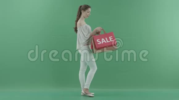 快乐女顾客在绿色屏幕上从包里拿出衣服视频的预览图
