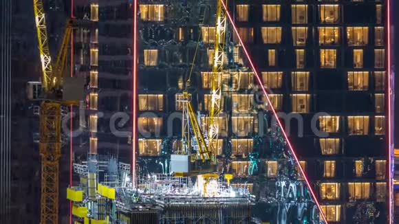 施工现场用吊车在JBR夜间计时建造摩天大楼视频的预览图