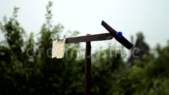 黑色手工风车在灰色的天空下雨后旋转视频的预览图