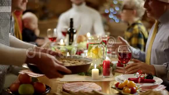 家庭主妇把主菜放在圣诞餐桌上把重点放在馅饼上然后放在其他人身上视频的预览图