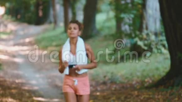 年轻美丽健康的运动女性在跑步锻炼后站在公园里快乐放松健康的生活方式视频的预览图
