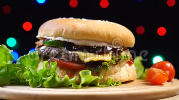 凉爽美丽新鲜多汁的熟食汉堡旋转在转盘的背景五颜六色的模糊的灯光视频的预览图