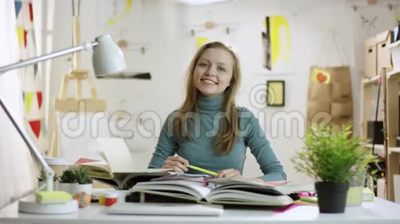 快乐的年轻学生坐在桌子旁视频的预览图