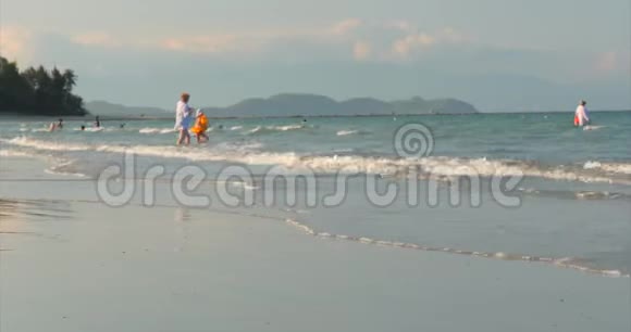 快乐和无忧无虑的人在海边玩耍游泳儿童和成人在热带海滩海边玩耍概念快乐视频的预览图