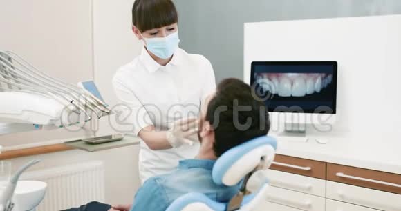 牙科医生在对男性进行牙科干预时与病人视频的预览图