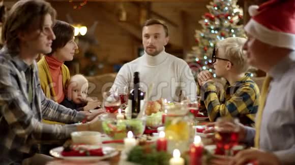 当一家人在圣诞餐桌旁聊天时女人把馅饼端上餐桌视频的预览图