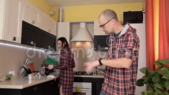在准备食物的时候男人和女孩在厨房里谈笑风生视频的预览图