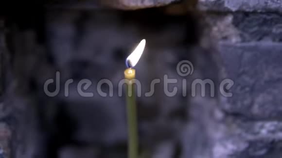 在一个古老的教堂里点燃蜡烛录像在深灰墙背景上点燃美丽的蜡烛视频的预览图