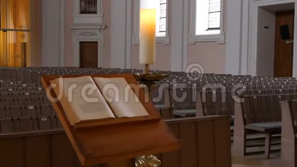 在一个空荡荡的天主教堂里为教会成员和牧师祈祷书的木桶视频的预览图
