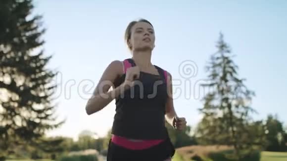 跑步的女人早晨在公园慢跑时擦额头上的汗视频的预览图