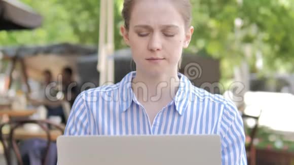 咖啡屋露台使用笔记本电脑的有头痛的女人视频的预览图
