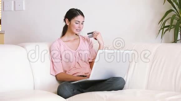 女士坐在沙发上用信用卡视频的预览图