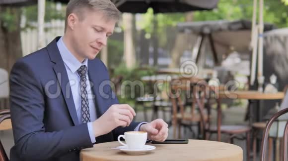 商务人士在室外咖啡厅边喝咖啡视频的预览图
