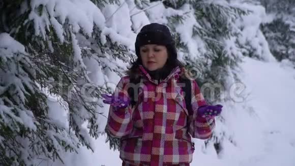 雪林中的年轻女子年轻漂亮的游客独自站在森林里环顾四周她捉到雪花视频的预览图