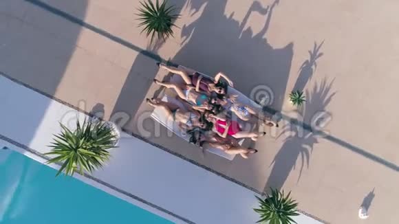 暑假期间活泼开朗的女性穿着泳衣戴着太阳镜躺在泳池边的躺椅上视频的预览图