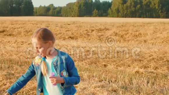 有趣的少女吹肥皂泡麦田景观视频的预览图