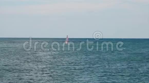 一个冲浪者在远处的海里游泳视频的预览图