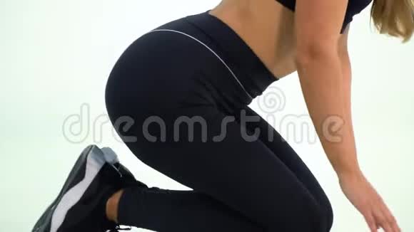 穿黑色运动服的金发女郎做腿部运动为相机摆姿势视频的预览图