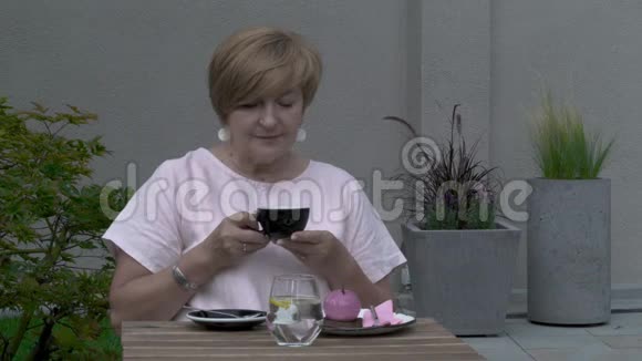 一位老妇人端着一杯茶环顾四周视频的预览图