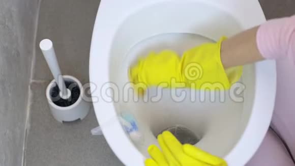 女孩用海绵用橡胶手套洗马桶视频的预览图