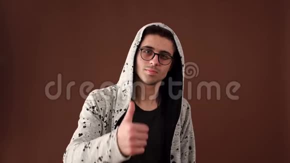 一个戴眼镜的年轻成功人士展示出成功的迹象竖起大拇指视频的预览图