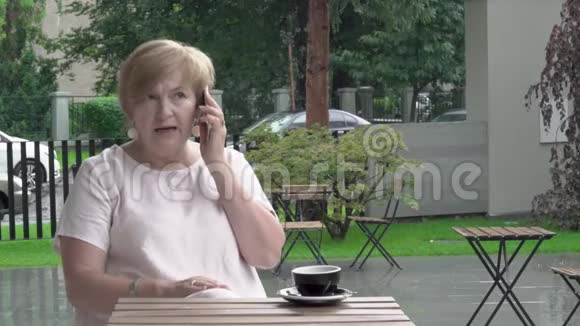 一位漂亮的老年妇女正在用电话情绪化地交谈她在解释回答视频的预览图