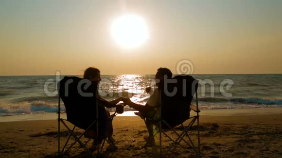 一对夫妇在岸上的折叠扶手椅上视频的预览图