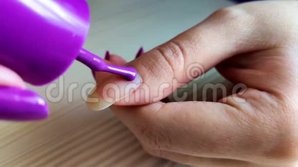 女人用紫色指甲油涂指甲视频的预览图