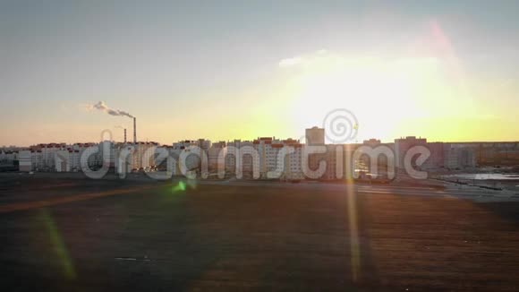 在夕阳和吸烟的背景下从空中展开拍摄到城市的一个新住宅区视频的预览图
