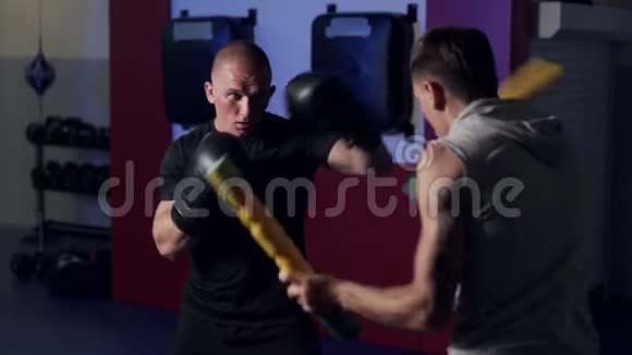 教练训练拳击手在健身房锻炼踢和防守慢动作视频的预览图
