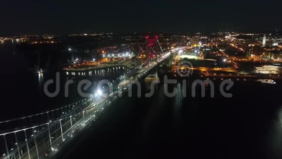 在令人惊叹的4k空中城市景观中在夜间灯光照明下在现代大费城市中心跨河大桥视频的预览图
