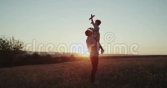 完美的时刻爸爸和他的儿子在日落时一起玩飞机男孩梦想将成为一名飞行员视频的预览图