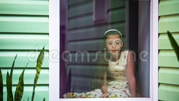 女孩坐在窗外等待着雨的结束视频的预览图