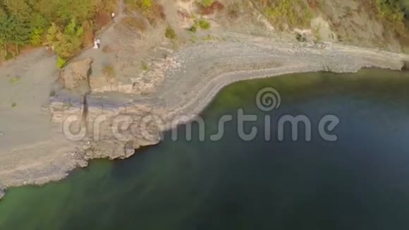 空中景色新娘和新郎在风景如画的河岸上巴科塔视频的预览图